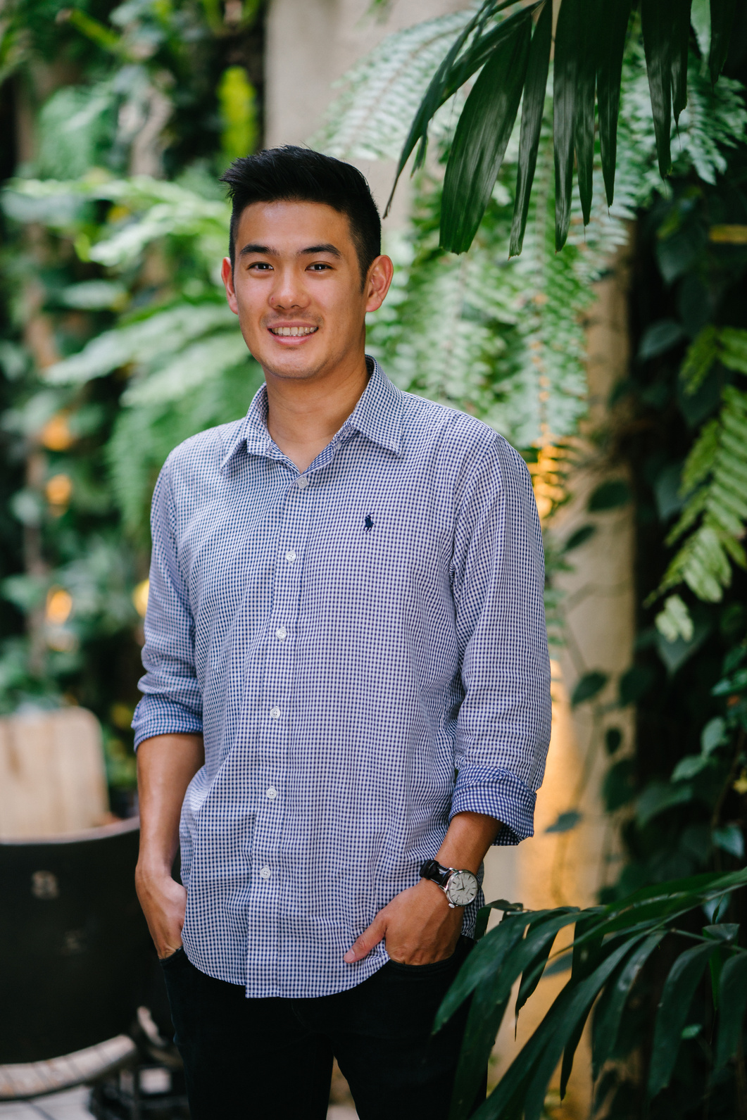 Man Wearing Blue Dress Shirt Standing Beside Green Plant